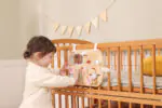 Дървен бизиборд VIGA Toys PolarB 44302 с 4 активности – огледалце, мъниста, зъбни колела и плъзгачи. Лесен монтаж към легло/кошара. Сертифициран.