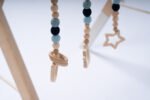 Стилна бебешка гимнастика Leg&Go от естествено дърво с три висящи сензорни играчки в меки сини и неутрални тонове. Насърчава зрителното възприятие, двигателната активност и любопитството на бебето още от първите месеци.