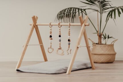 Дървена бебешка гимнастика Leg&Go с висящи сензорни играчки. Стимулира зрението, моториката и любопитството на бебето. Подходяща за игра от първите месеци.