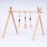 Дървена бебешка гимнастика Leg&Go с висящи сензорни играчки. Стимулира зрението, моториката и любопитството на бебето. Подходяща за игра от първите месеци.