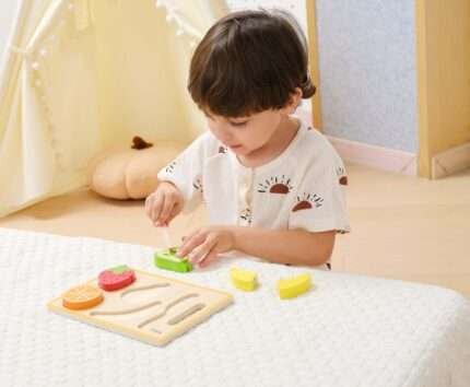 Дете играе с дървени плодове за рязане VIGA Toys
